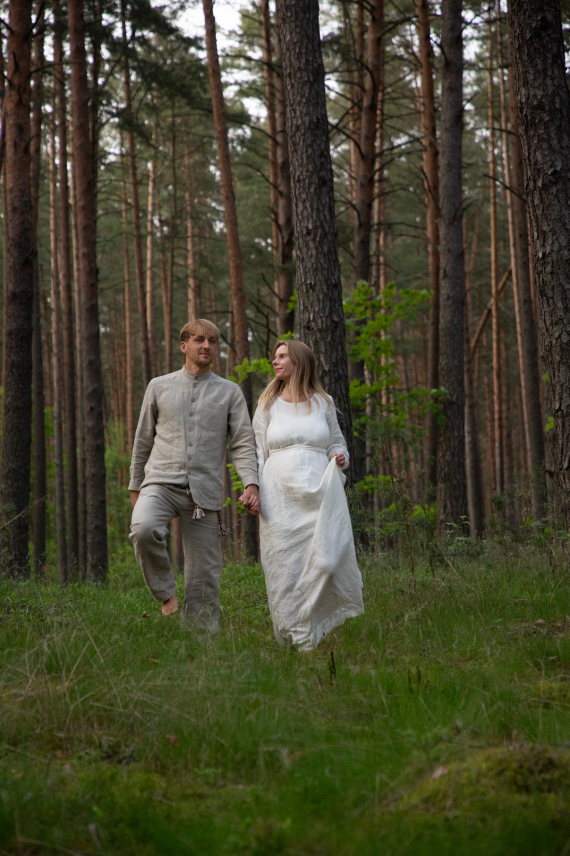 A couple walking through a pine forest in Aukštaitija